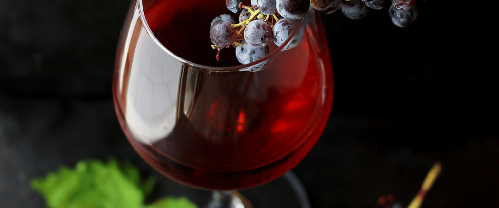 red wine in glass with red grapes